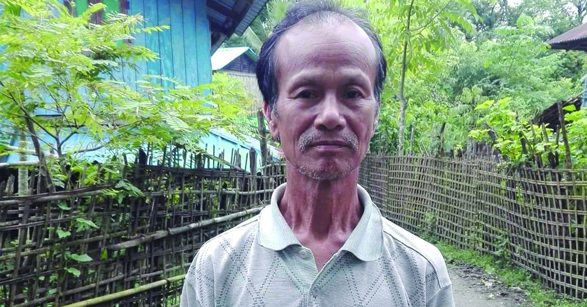 A mature Myanmar man in front of his house