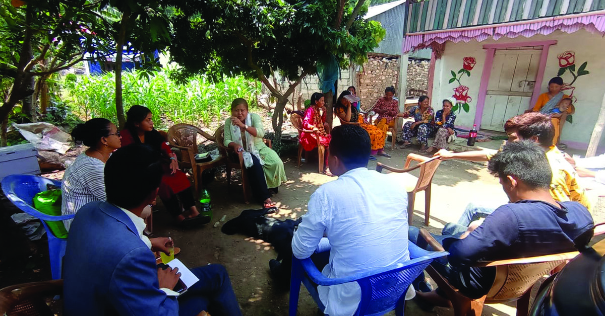 A small group of villagers attending a TCD meeting outdoors.