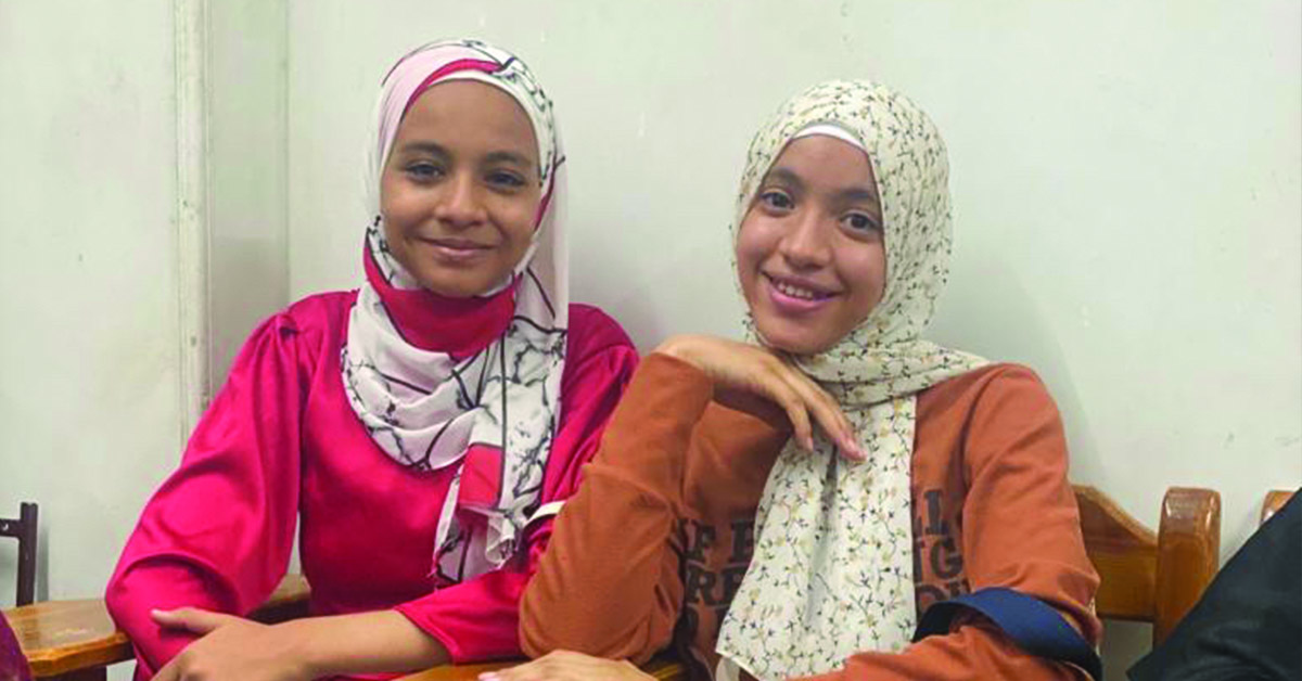 Two Egyptian teenagers sitting together.