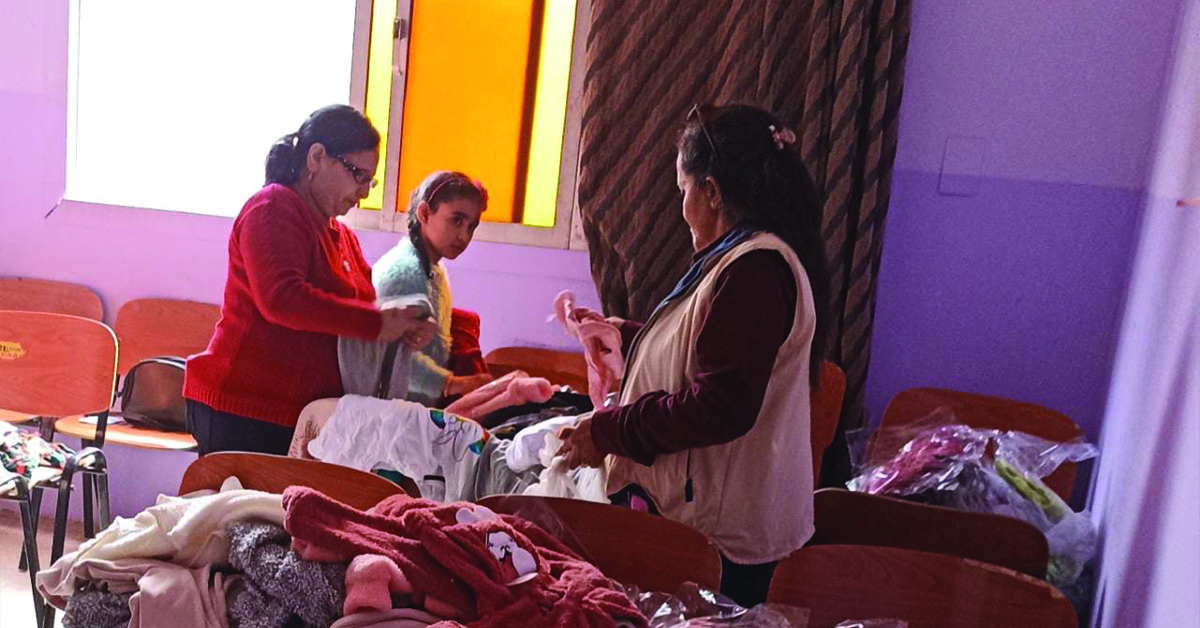 A mother and daughter shopping for clothes at a clothing drive