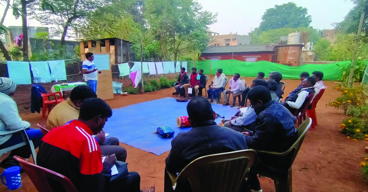 Village leaders listening to their TCD training outdoors.