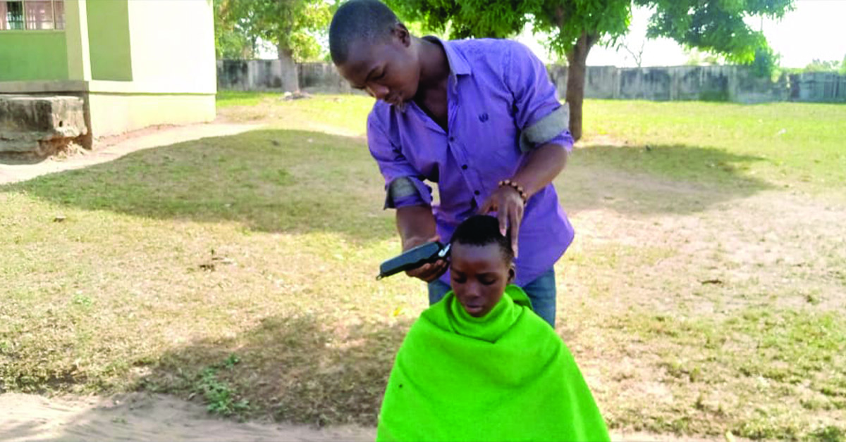 A Nigerian boy getting a haircut.