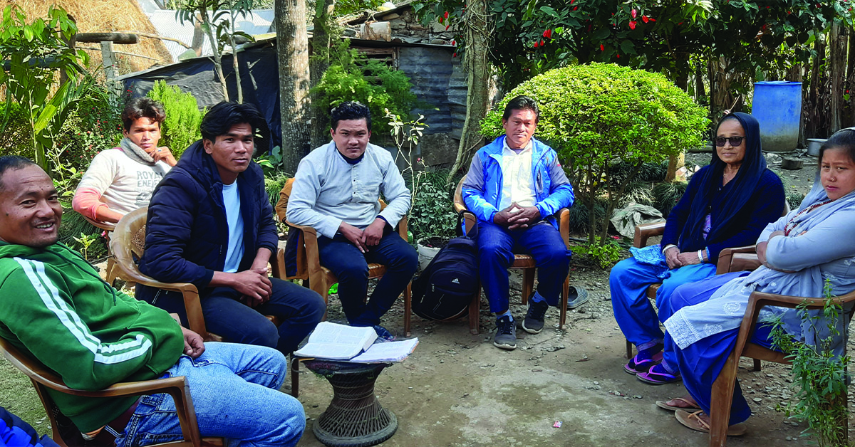 TCD members sitting outdoors w/ key Chainpur villagers