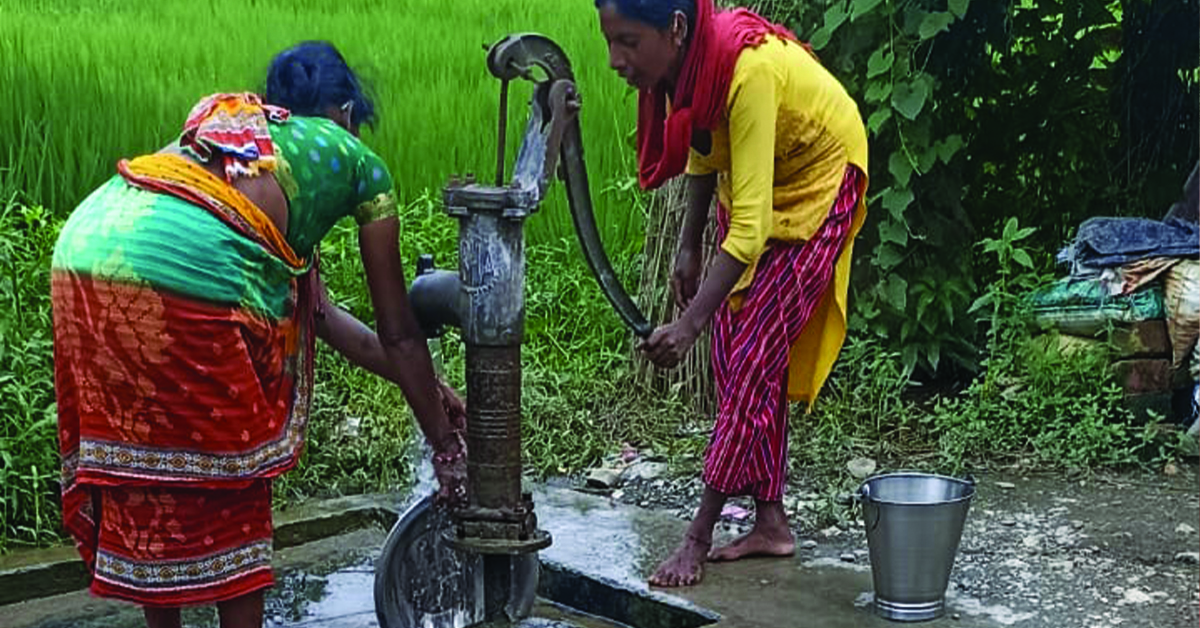 Two Nepal women using a water pump.
